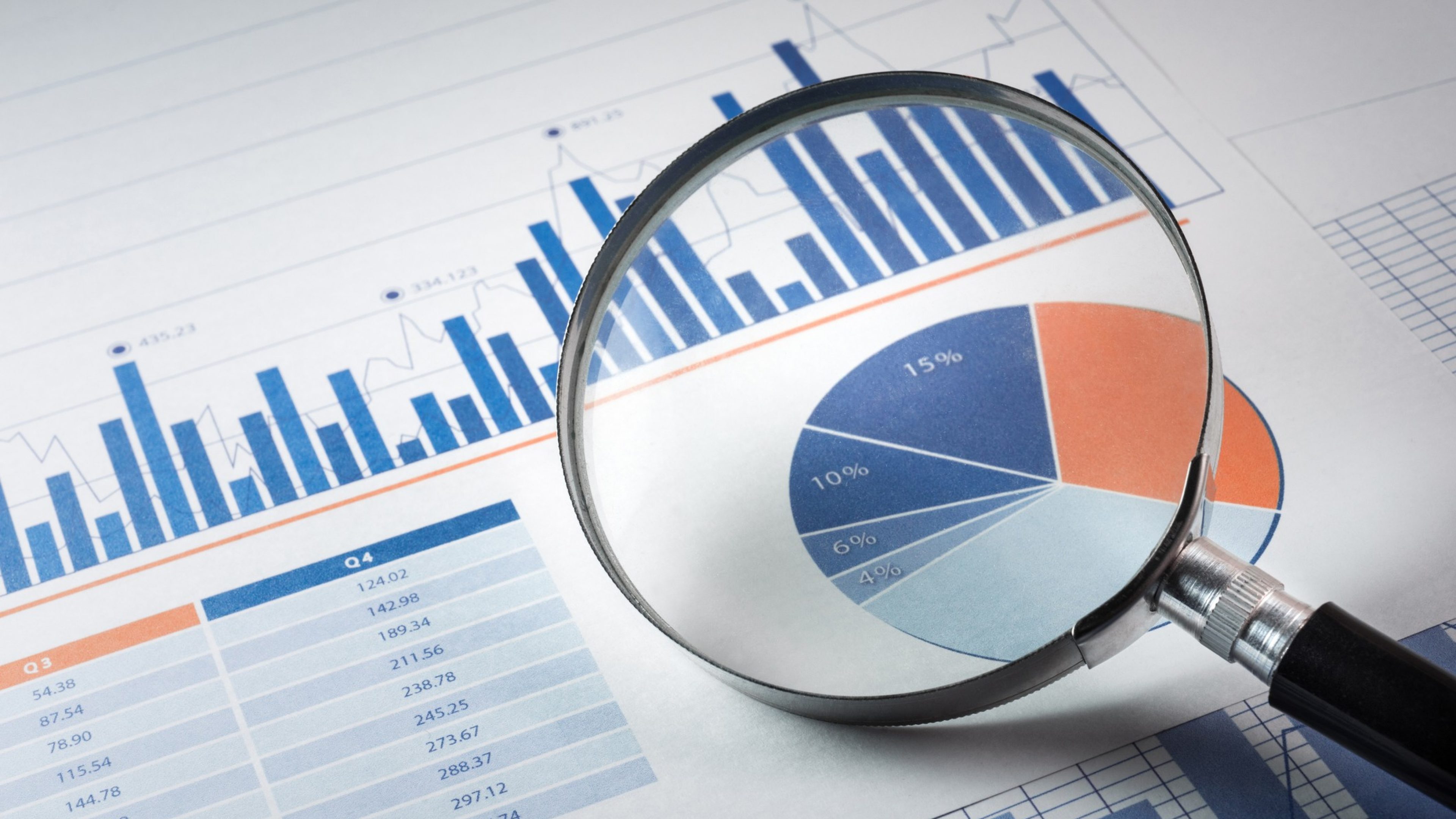 Magnifying glass and business growth graph / financial graph on paper./ For business concept.