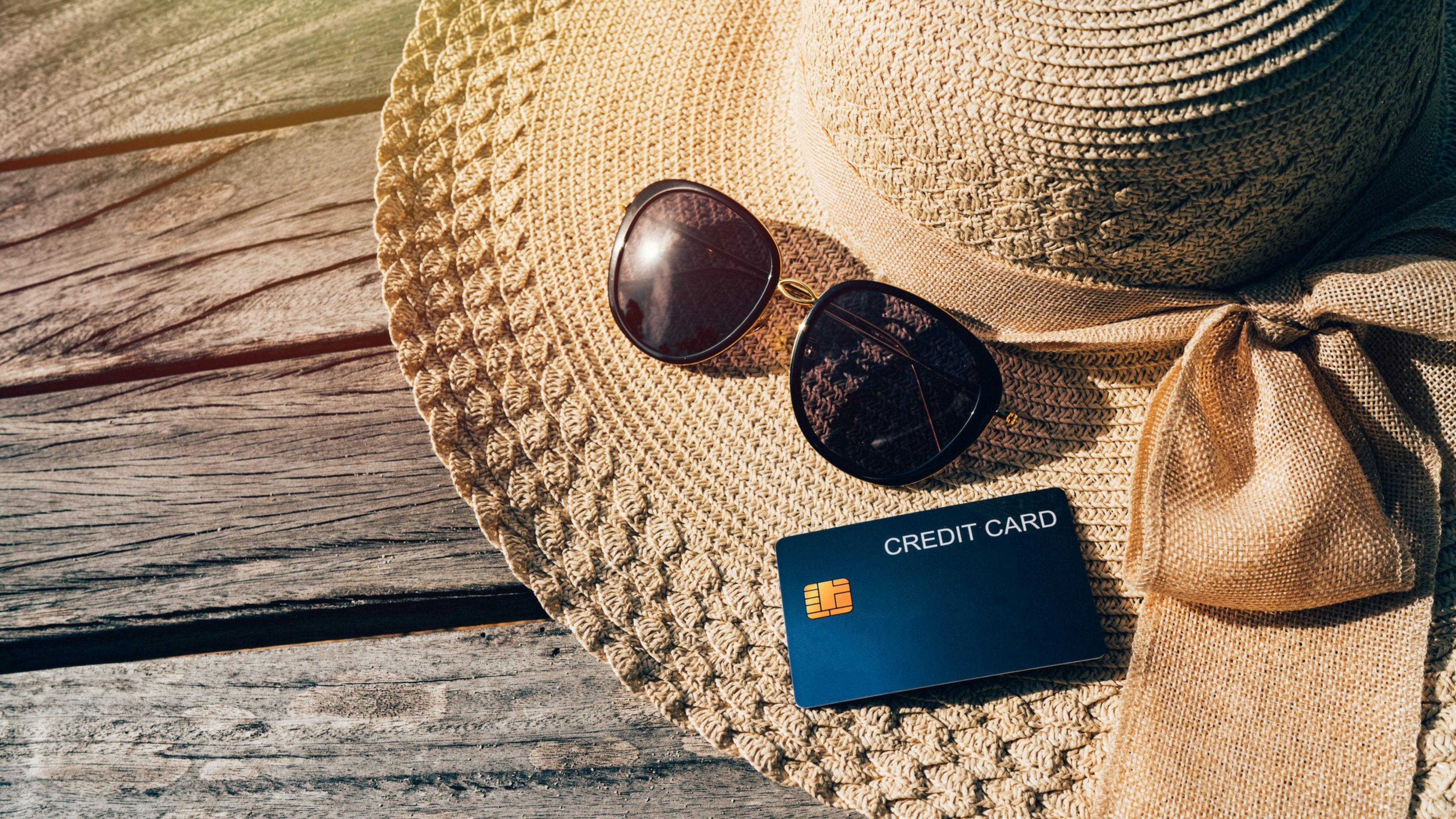 Credit card and accessories for the holiday, sun glasses and sea hat on the wood bridge, copy space.