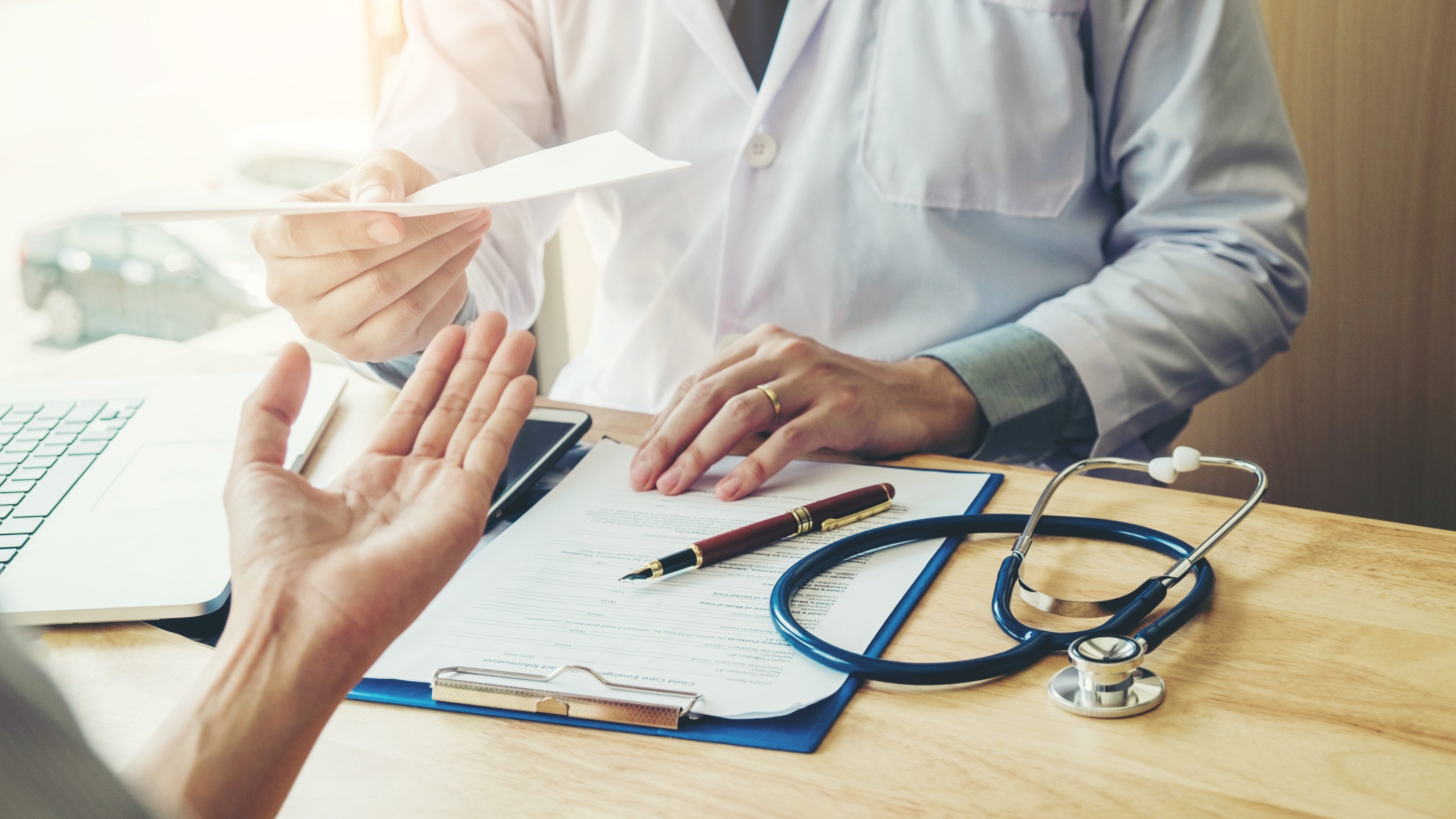 Doctor or physician writing diagnosis and giving a medical prescription to female Patient