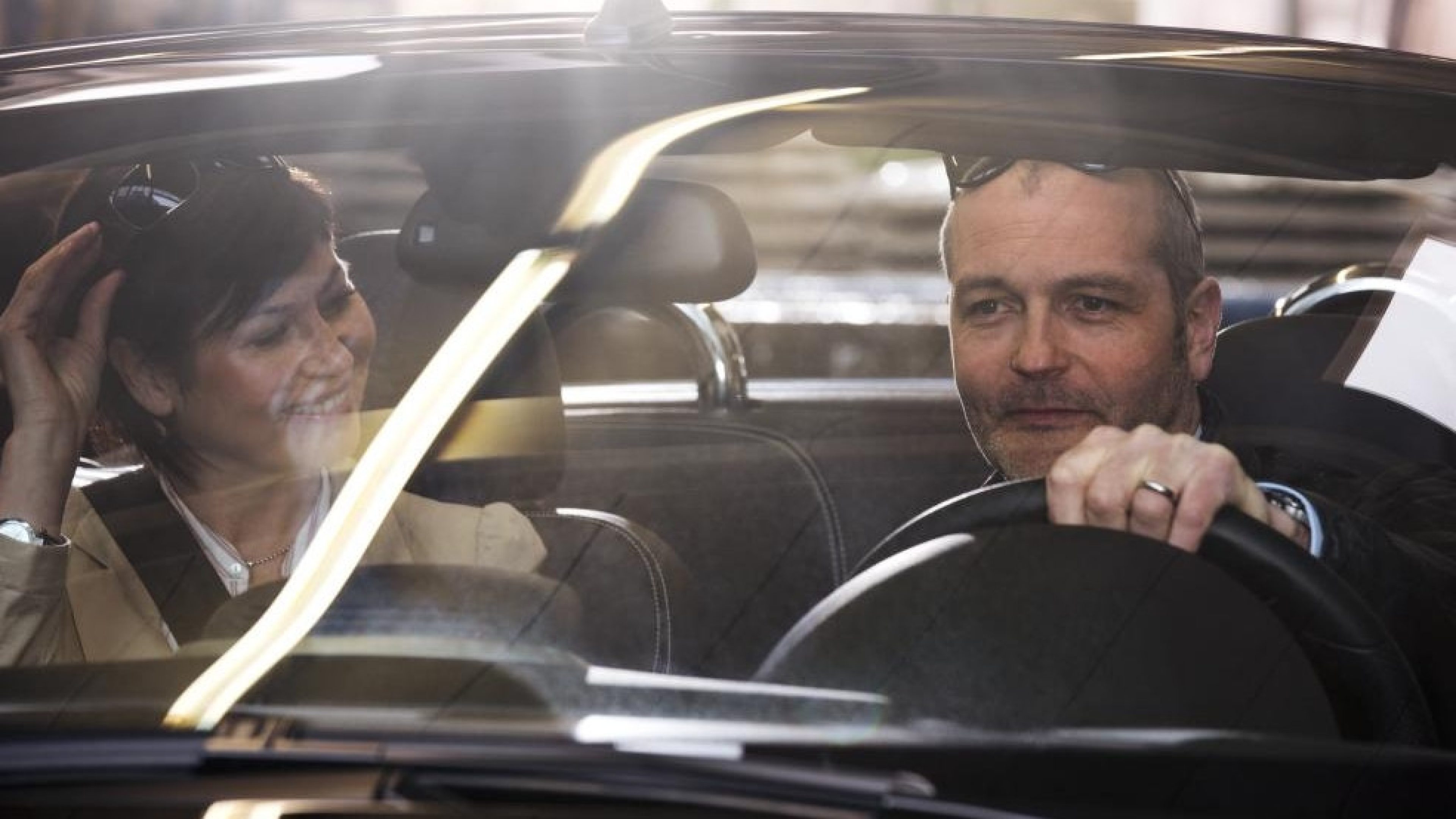 Personnes assises dans une voiture, regardant à travers le pare-brise depuis l’intérieur du véhicule.