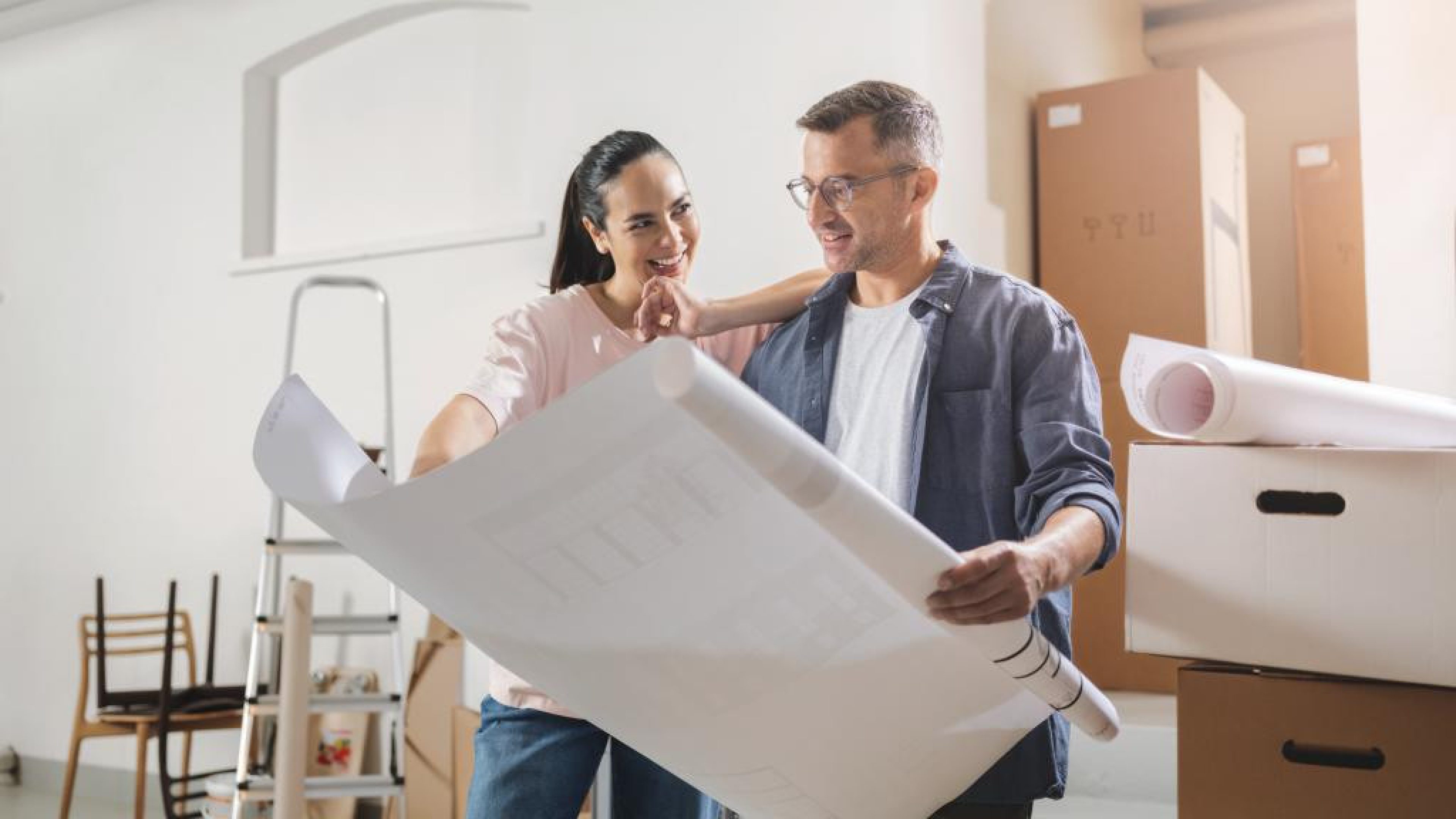 Deux personnes regardent des plans, entourés de cartons