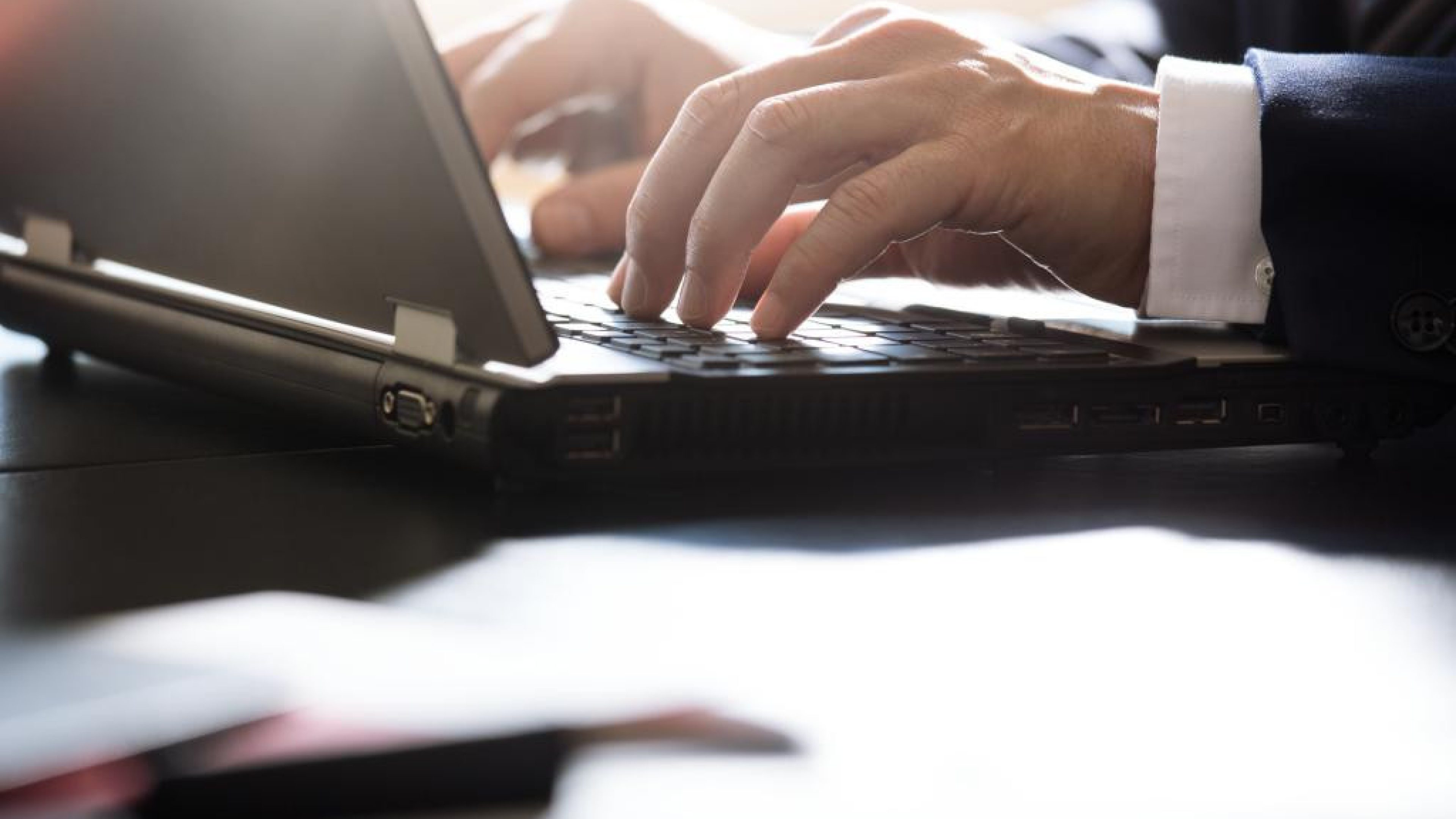 Mains en train de taper sur le clavier d'un ordinateur