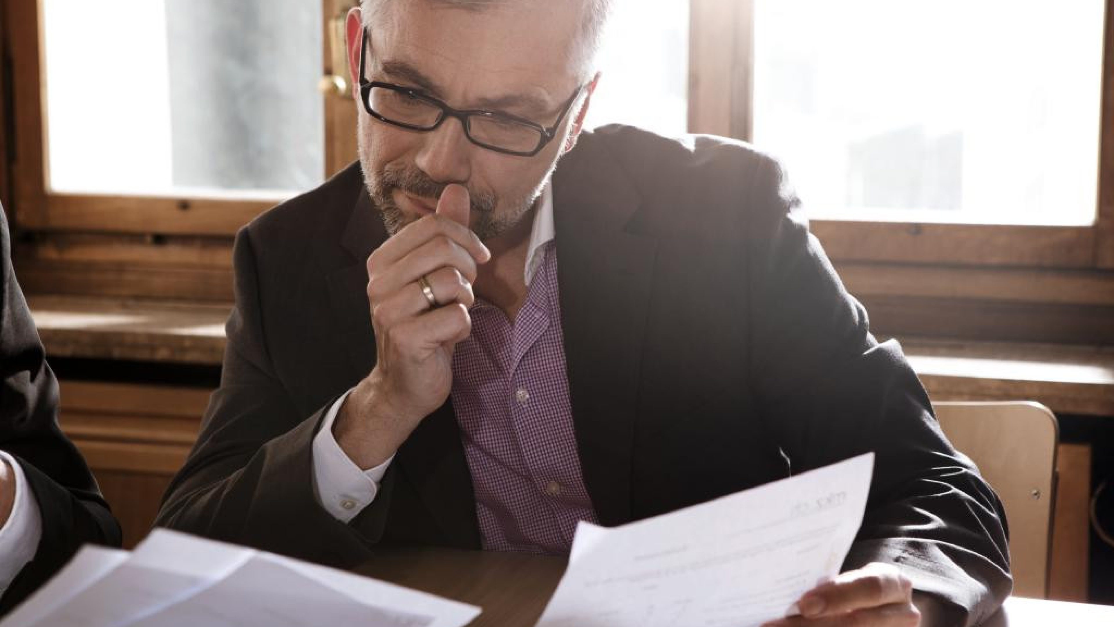 Un homme étudie des documents à son bureau