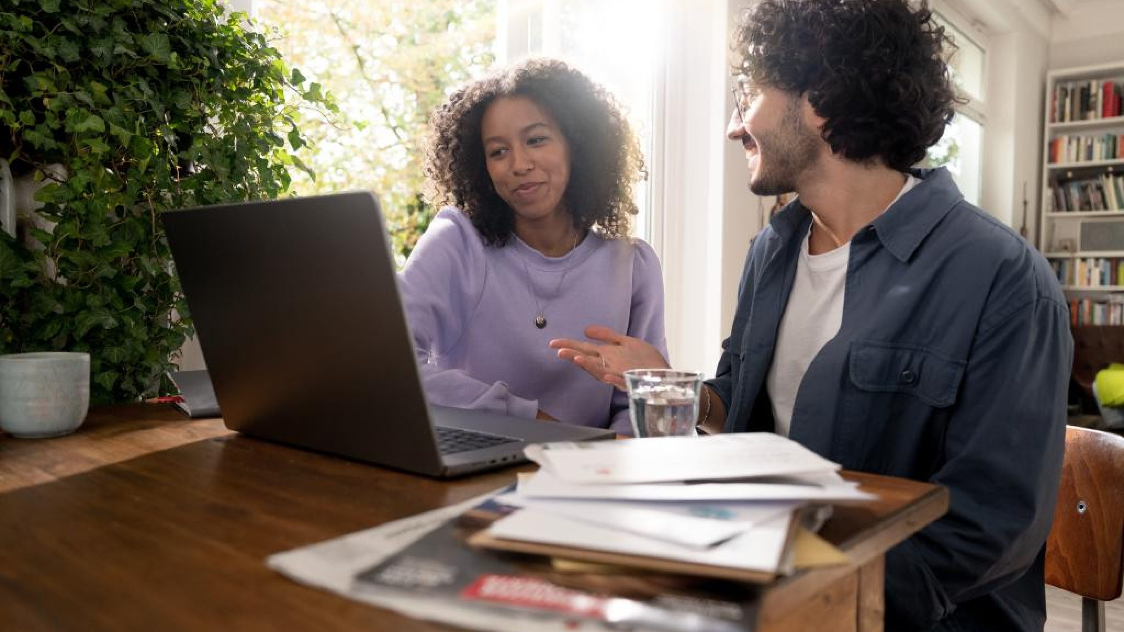 Une jeune femme et un jeune homme en interaction devant leur ordinateur 